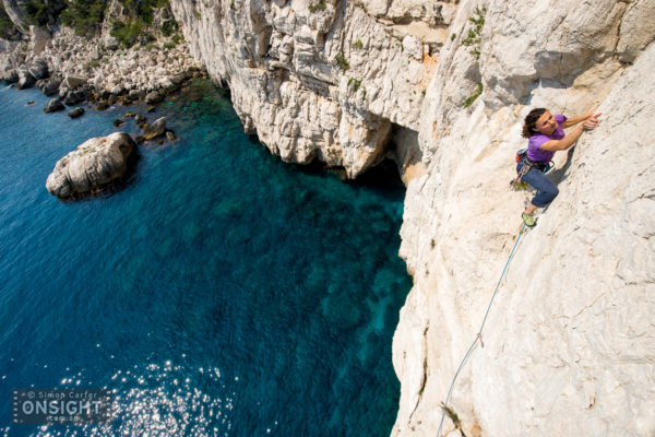 Nadine Rousselot leading the final pitch of the 9 pitch traverse La Commune (6b) at Les Calanques, on the Mediterranean, in the south of France. The route actually starts from the rocky "beach" in the background!