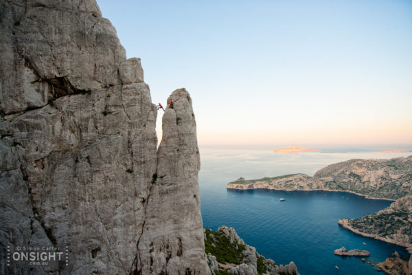 Sunrise finds Nadine Rousselot and Mathieu Geoffray an hours hike in and two pitches up Arête de Marseille (5c). It is a five pitch Calanque’s classic first climbed in 1927, on La Grande Candelle, overlooking the Mediterranean, France.